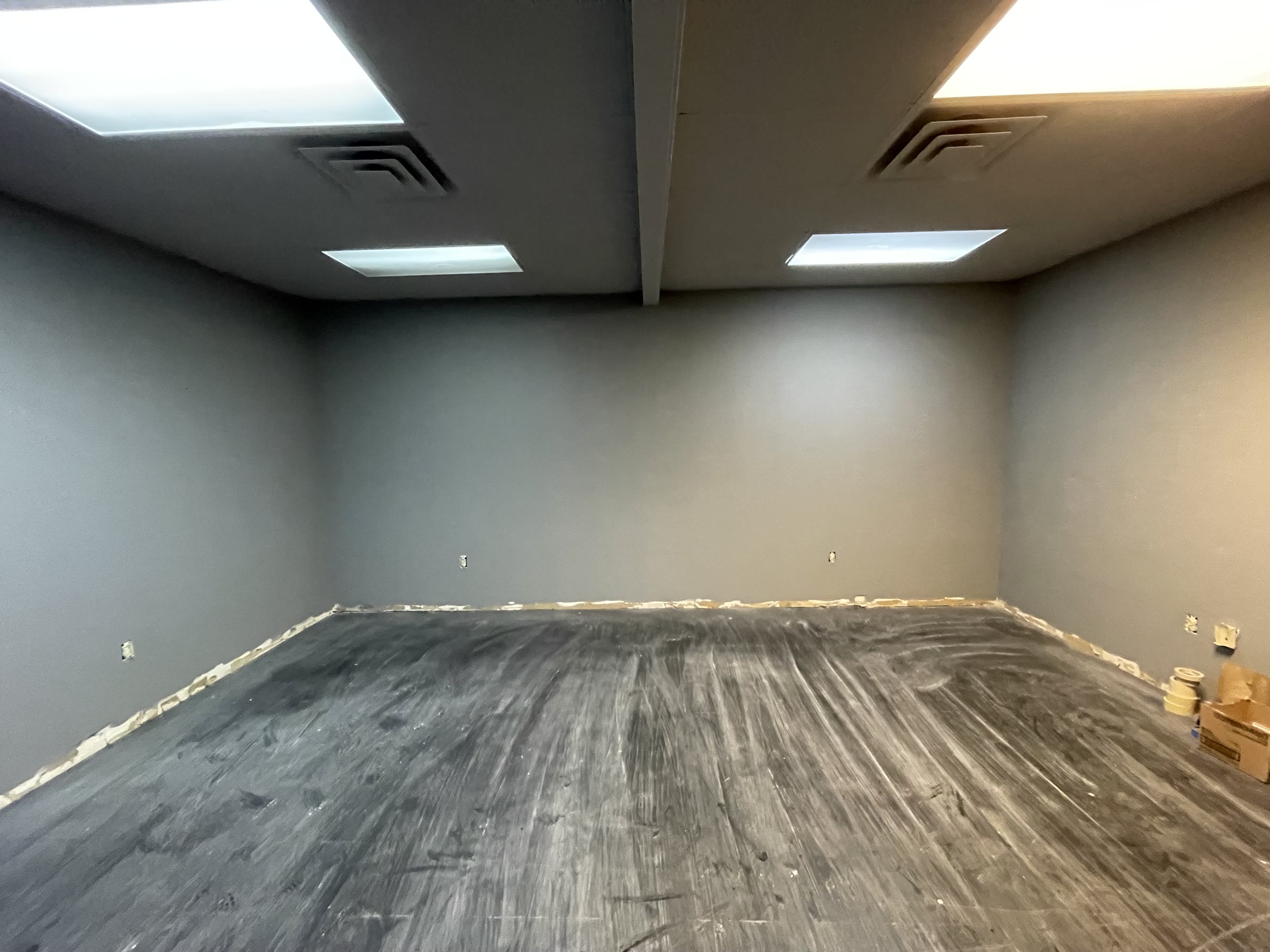 Freshly painted studio buildout with flooring removed during construction