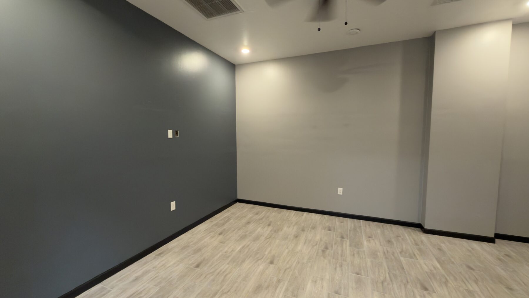 The completed office interior showing its dark accent wall and new flooring.