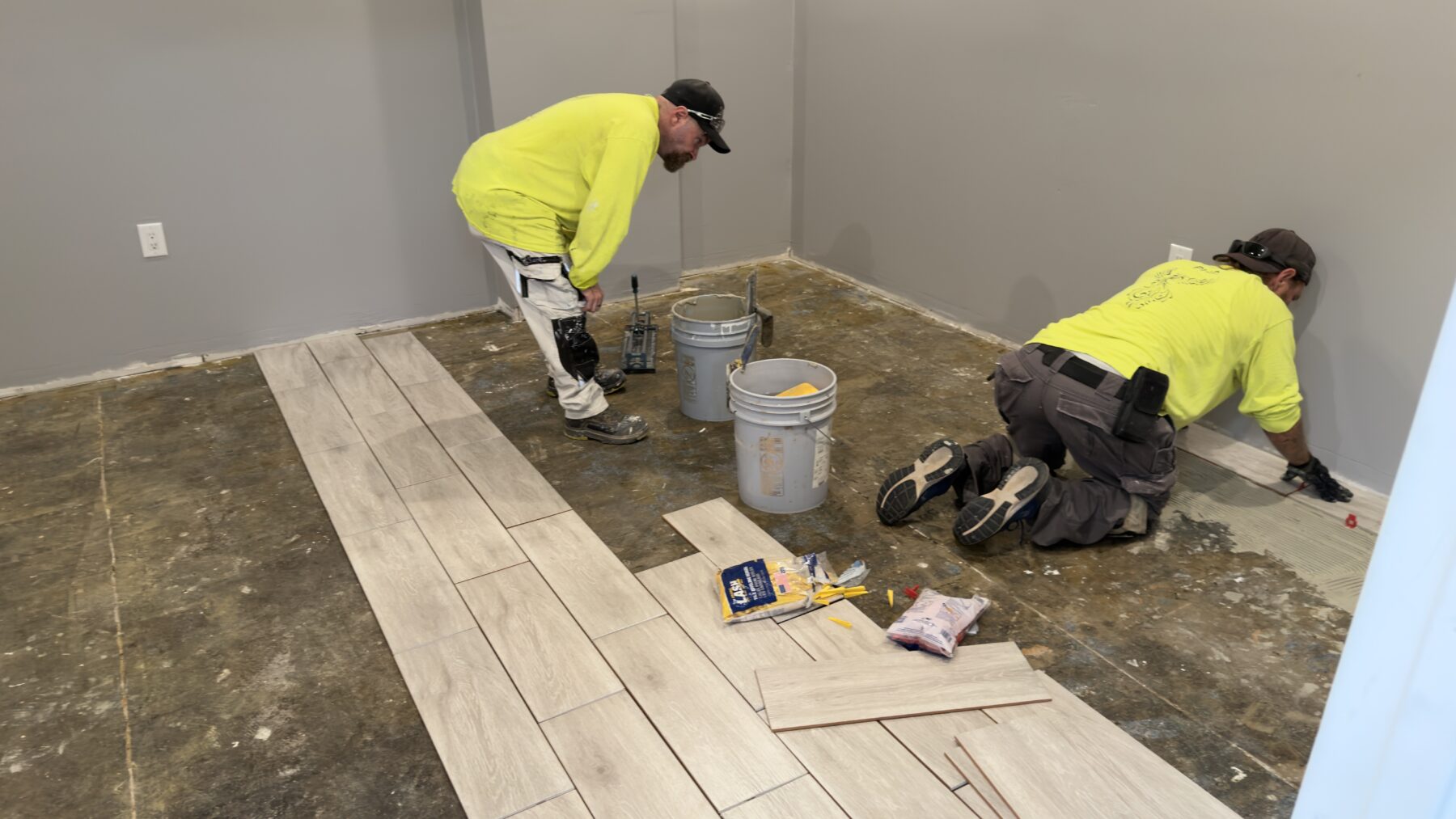 PHP crew members installing wood-look flooring in Tommy Miller’s future office.