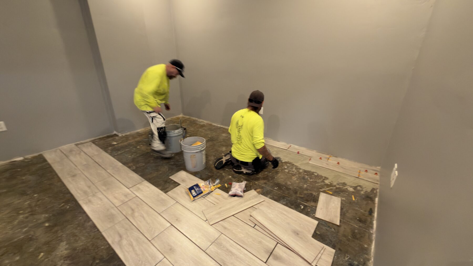 Two PHP crew members working on the office floor during the remodel.